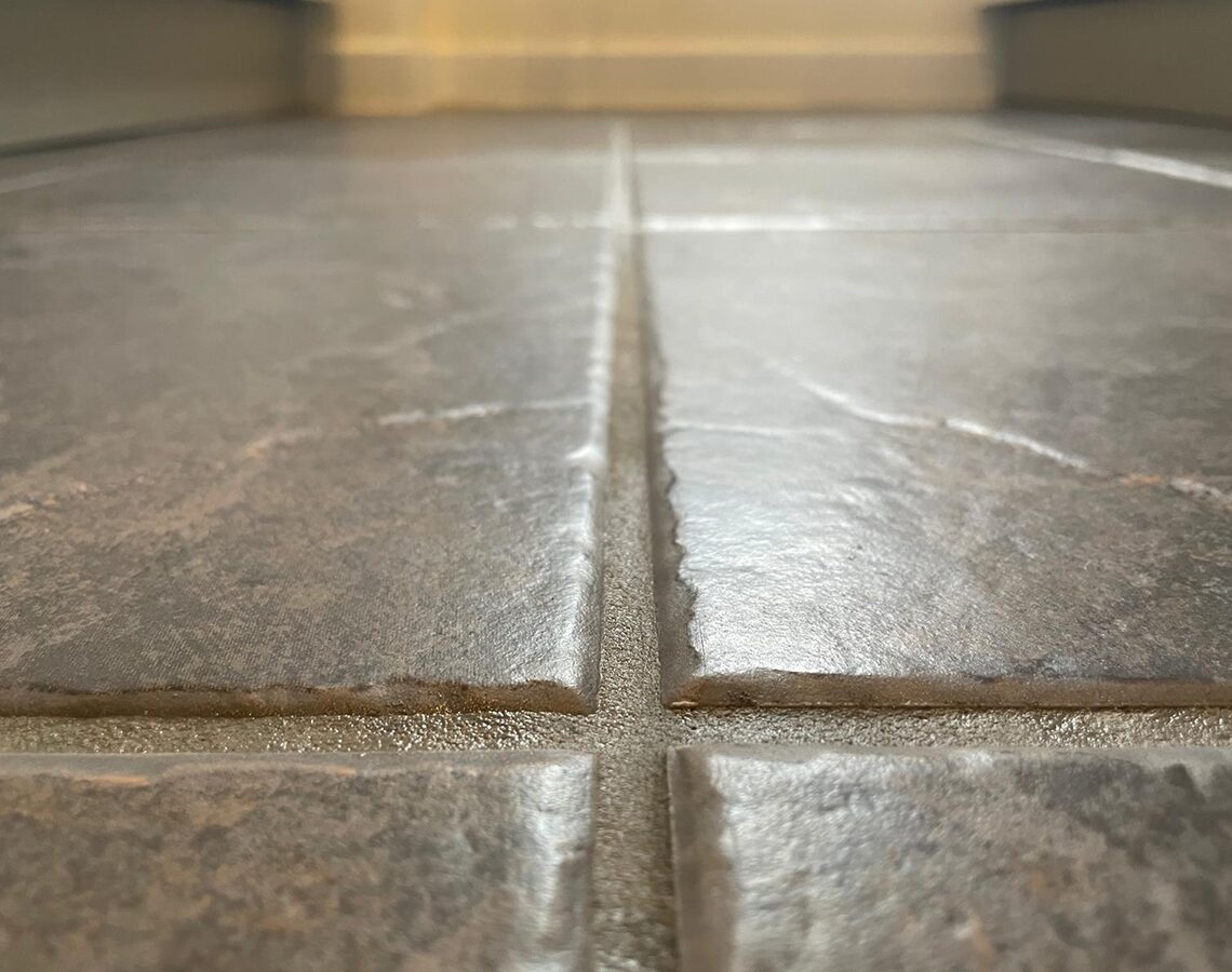 Grimy, discoloured grout lines before recolouring